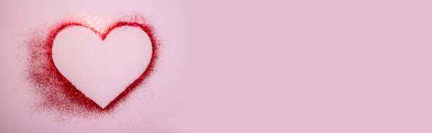 粉粉色背景上亮片制成的红心。情人节快乐的横幅图片下载