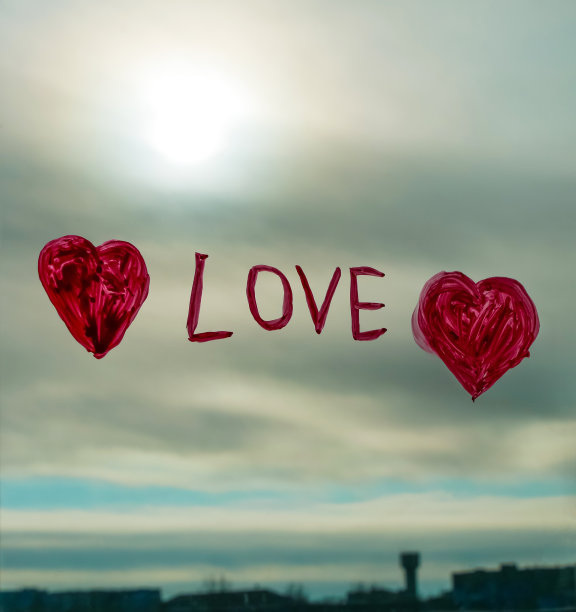 小女孩手拿画笔在窗玻璃上画红心。33、情人节爱情，相亲，检疫休闲图片下载