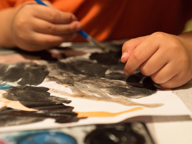 手的孩子画画。蓝色的颜色。艺术，绘画，回到学校，孩子和艺术概念图片下载