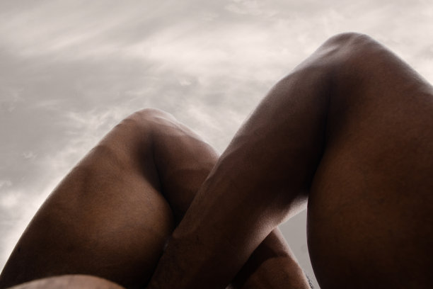 详细的人体皮肤纹理。近距离拍摄年轻的非洲裔美国男性身体像风景与天空的背景图片下载