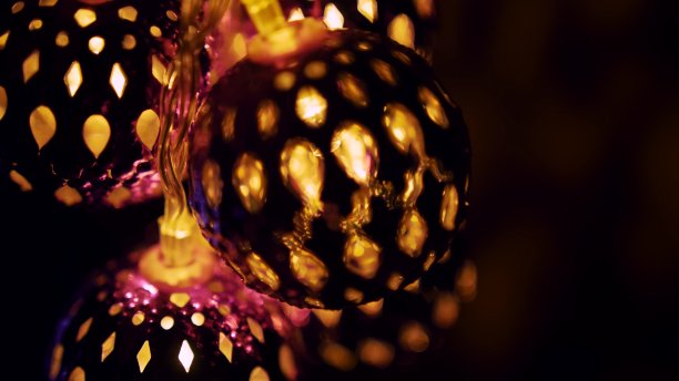 神奇的灯笼旋转，给墙壁带来美丽的眩光。手持led发光球。暖暖的灯照亮圣诞的心情。图片下载