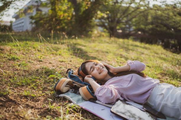 女人戴着耳机在户外愉快地听音乐图片下载