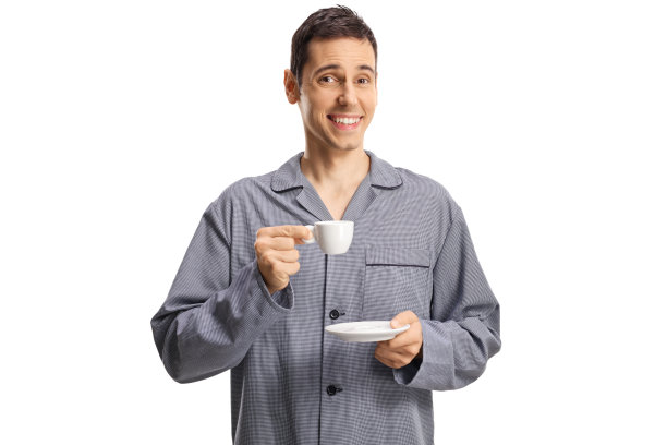 一个穿着睡衣微笑着喝着咖啡的年轻人图片下载