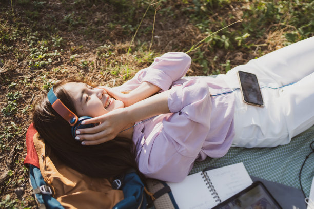 女人戴着耳机在户外愉快地听音乐图片下载