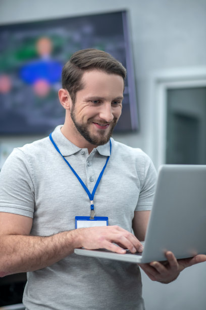 有兴趣的年轻人站在笔记本电脑上工作图片下载