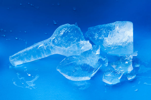 蓝色背景上的干净、透明、天然冰的碎瓶。纯净清新理念，冰饮图片下载