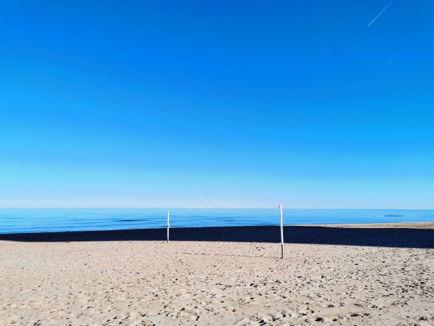 海滩环境宁静祥和。蓝天和沙滩图片下载