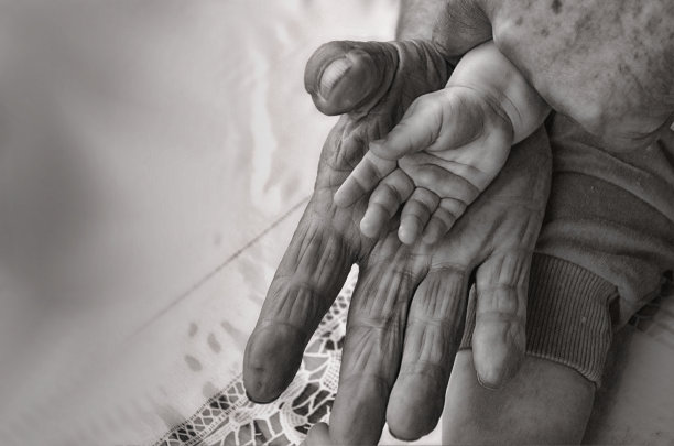 一个孩子的小手在一个老人的手里——一代又小又大的手图片下载