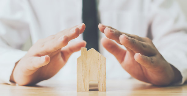 保险房和储蓄房产投资房地产概念。男人双手防止木制家居图片下载