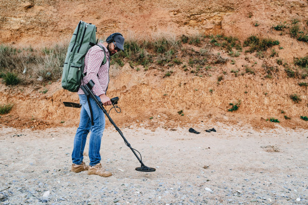 带着金属探测器的人在海滩上寻找丢失的财宝图片下载