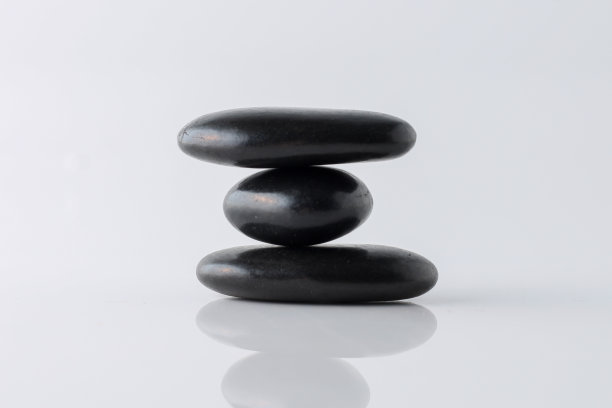 堆放在白色背景上的黑色石头图片下载