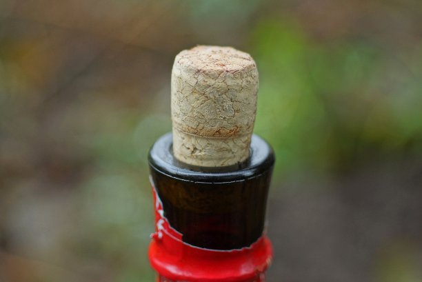 用棕色软木塞塞住葡萄酒的玻璃瓶的一部分图片下载