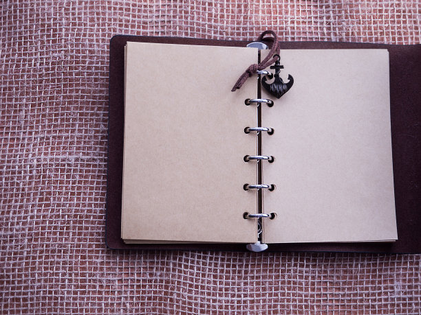 桌上放着一个复古记事本。笔记本。图片下载