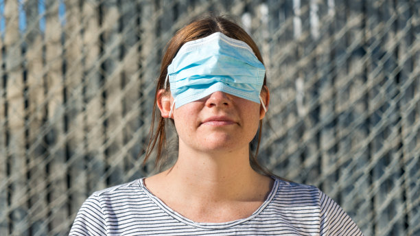 一个女人用错误的方式戴着面具遮住眼睛的傻照片图片下载