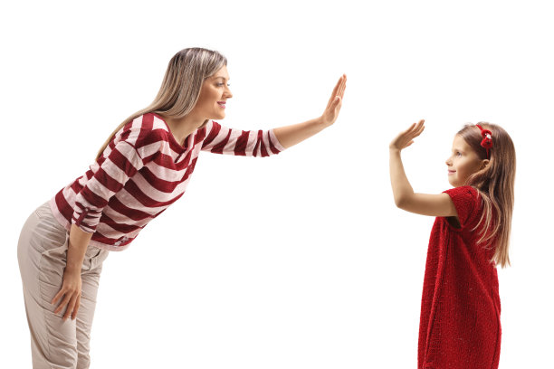 一个女人在和一个穿红裙子的女孩击掌图片下载