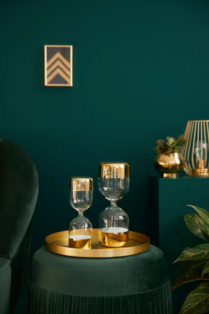 垂直照片优雅的客厅与绿色天鹅绒pouf，金色装饰，设计沙漏，画框在墙上和优雅的配件。舒适之家的豪华室内元素。模板。图片下载