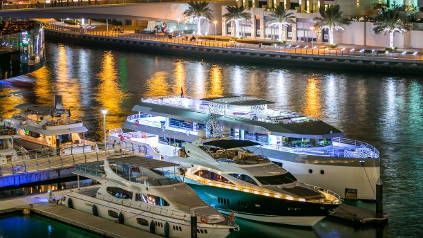 迪拜码头大厦和运河中游艇夜间延时摄影图片下载