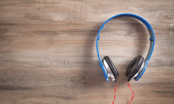 木制背景上的蓝色耳机。图片下载
