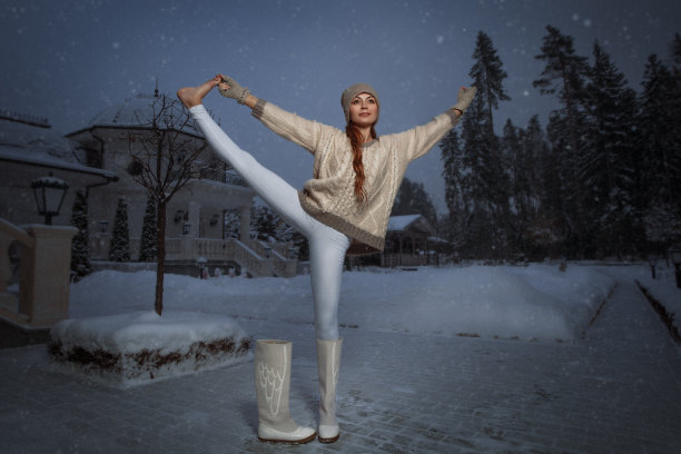 年轻女子在一个冬季公园里练习瑜伽图片下载
