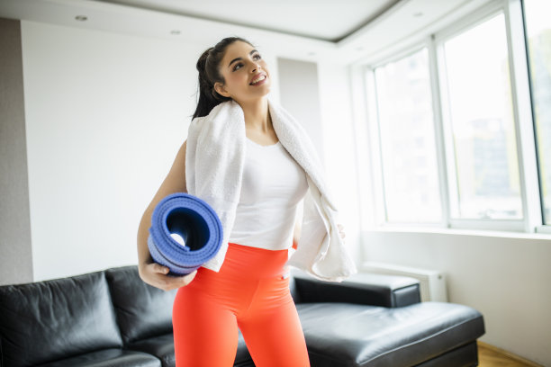 累，但快乐:健康的女人在家锻炼后用毛巾擦脸图片下载