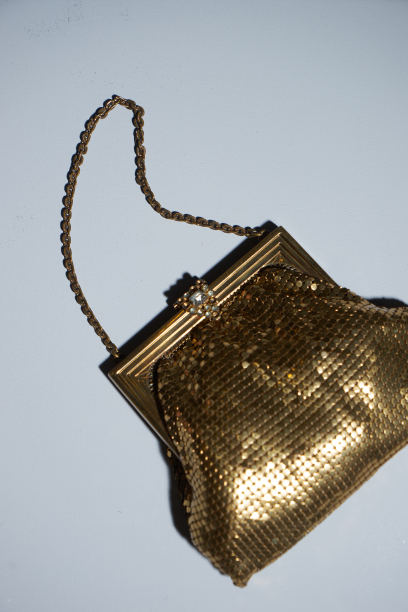 女人手里拿着金色的钱包。蓝色背景的女手提包图片下载