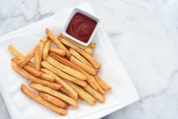 法式炸薯条配番茄酱，白色盘子，大理石桌子图片下载