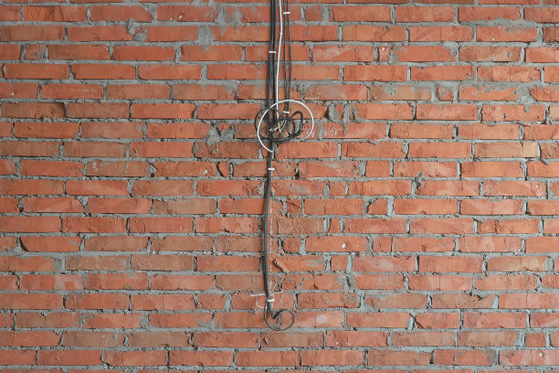 砖墙上的几根电缆，用于在在建房屋中安装未来的插座图片下载