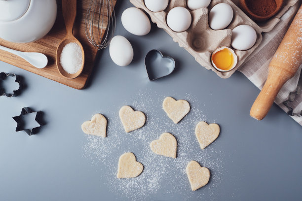 心形的饼干。灰色背景上自制饼干的配料。为情人节、父亲节或母亲节烹饪糖果的概念。平铺，俯视图图片下载