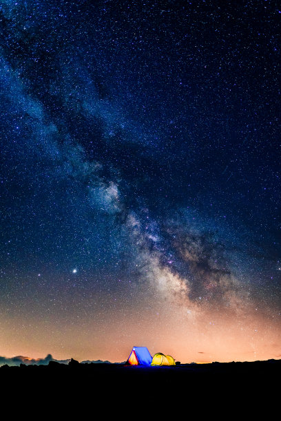晚上在银河下发光的帐篷。在星空下的山上露营。露营和野生动物的概念。真正的户外探险。图片下载