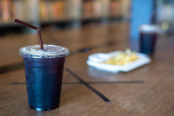 在新冠肺炎疫情中采取社交距离措施时，废弃的美食广场上的美式冰咖啡图片下载