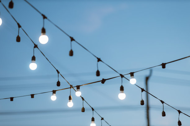 在户外聚会上用灯泡装饰蓝天。图片下载