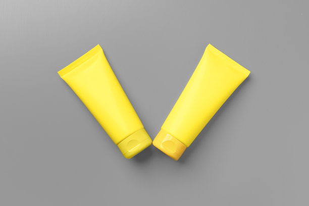 黄色化妆品容器上的灰色背景俯视图图片下载
