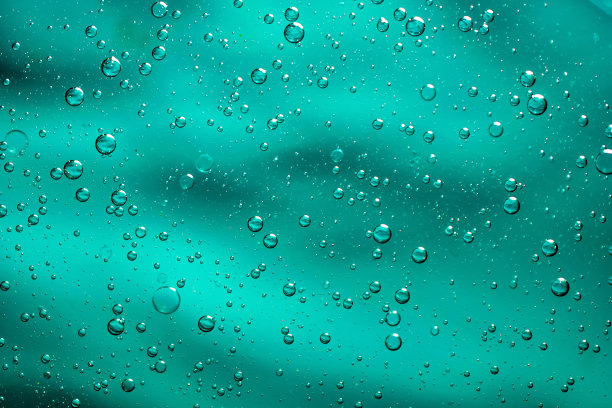 在蓝色背景上，油滴在水上图片下载