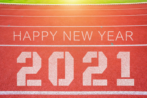 体育场的白色线条和跑道的纹理红色橡胶跑道与2021年新年快乐的文本，在圣诞和新年期间。图片下载