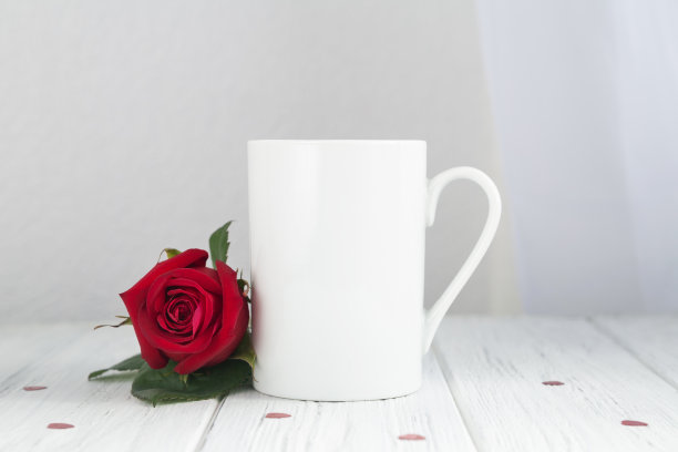 情人节咖啡杯，杯子放在木桌上，白底红玫瑰图片下载