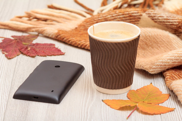 一杯咖啡，手机和枯叶在一个秋天静寂的生活。图片下载