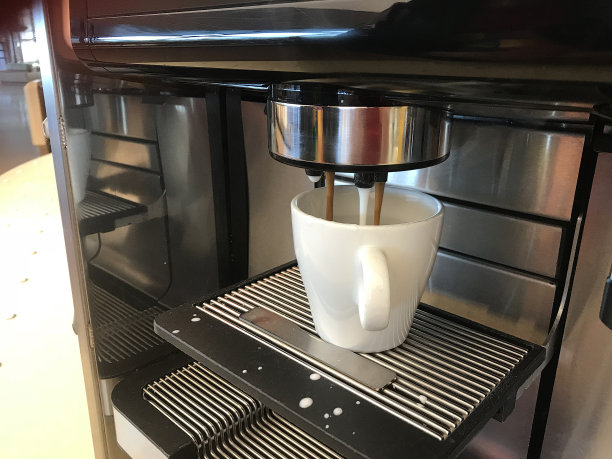 意式浓缩咖啡机用白色杯子制作新鲜的卡布奇诺咖啡图片下载