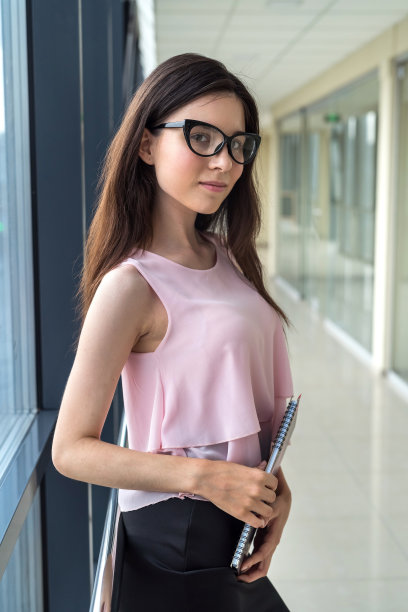年轻的单身女商人拿着记事本站在商务中心图片下载