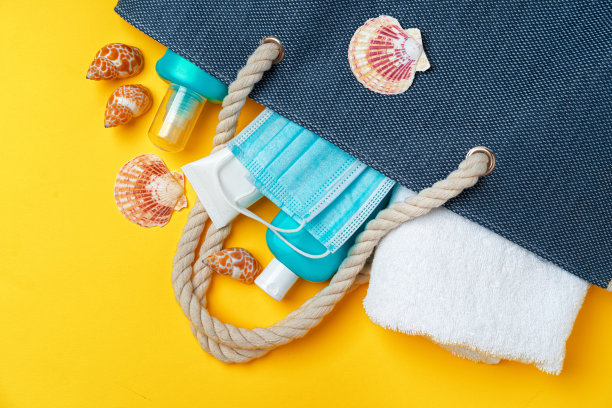 蓝色沙滩包与沙滩配件和保护面具在黄色背景图片下载