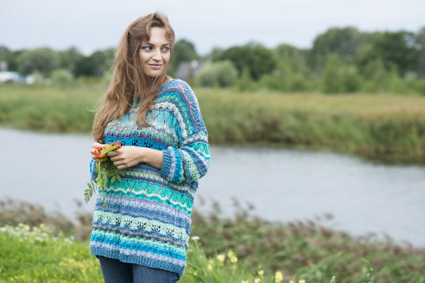 女人在编织蓝色手工毛衣摆姿势在自然图片下载