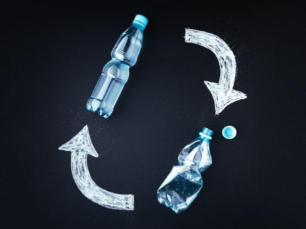 塑料瓶回收理念。黑板上，塑料瓶上用粉笔画上回收标志图片下载