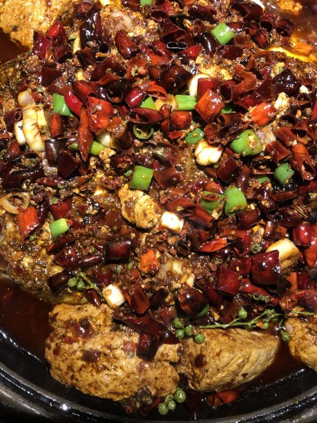 这是中国四川成都的一家当地餐馆，在红辣椒油(中文:马拉辣椒油)中，可以看到川菜的烤鱼和豆腐图片下载