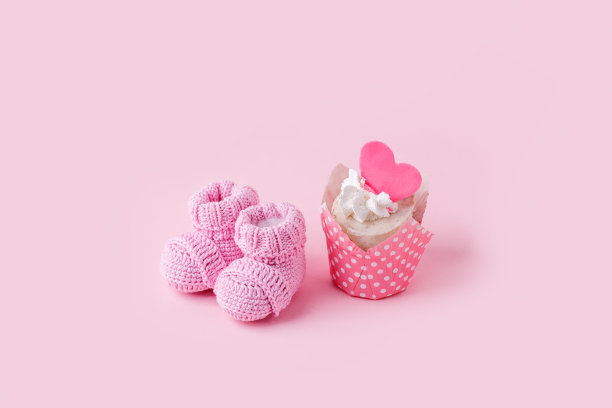 节日背景装饰的生日庆祝美味Ñ蛋糕和针织靴宝宝送礼粉红色的背景，第一个生日概念，派对，单色图片下载