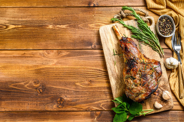 烤羊腿配香草。农场的肉。木制背景。前视图。本空间图片下载