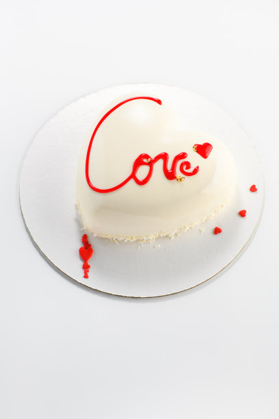 心形的蛋糕。奶油轻蛋糕形状的心与铭文的爱情在灰色的背景。情人节。垂直图图片下载