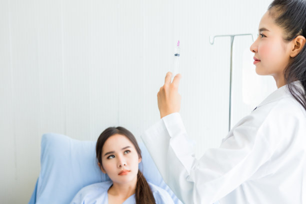 亚洲年轻女医生与注射器亚洲年轻女病人在床上更好的愈合在病房医院背景。图片下载