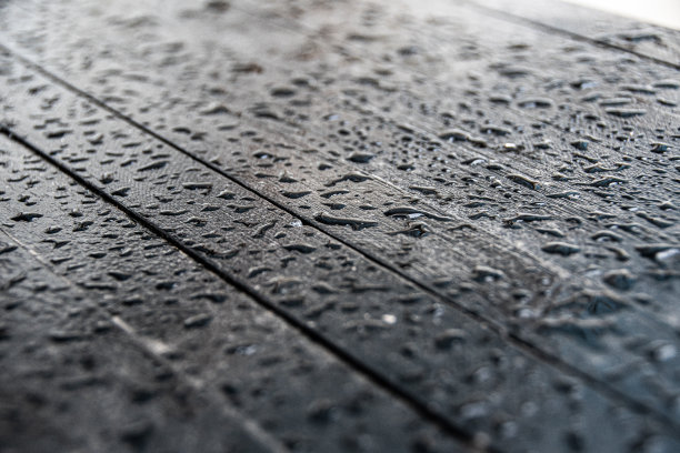 水滴落在木桌的黑色表面上图片下载