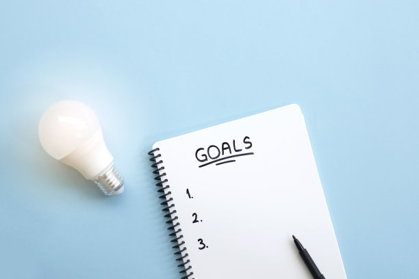 顶视图的空白笔记本与发光的灯泡在蓝色的背景，有新的想法的概念图片下载