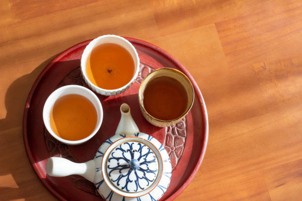 一个热水饮料与九州和烤绿茶放在一个阳光明媚的桌子图片下载