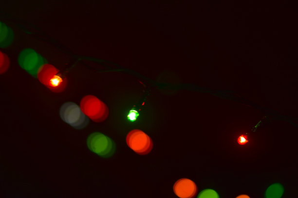 圣诞彩灯在黑暗中发出五彩缤纷的光芒图片下载